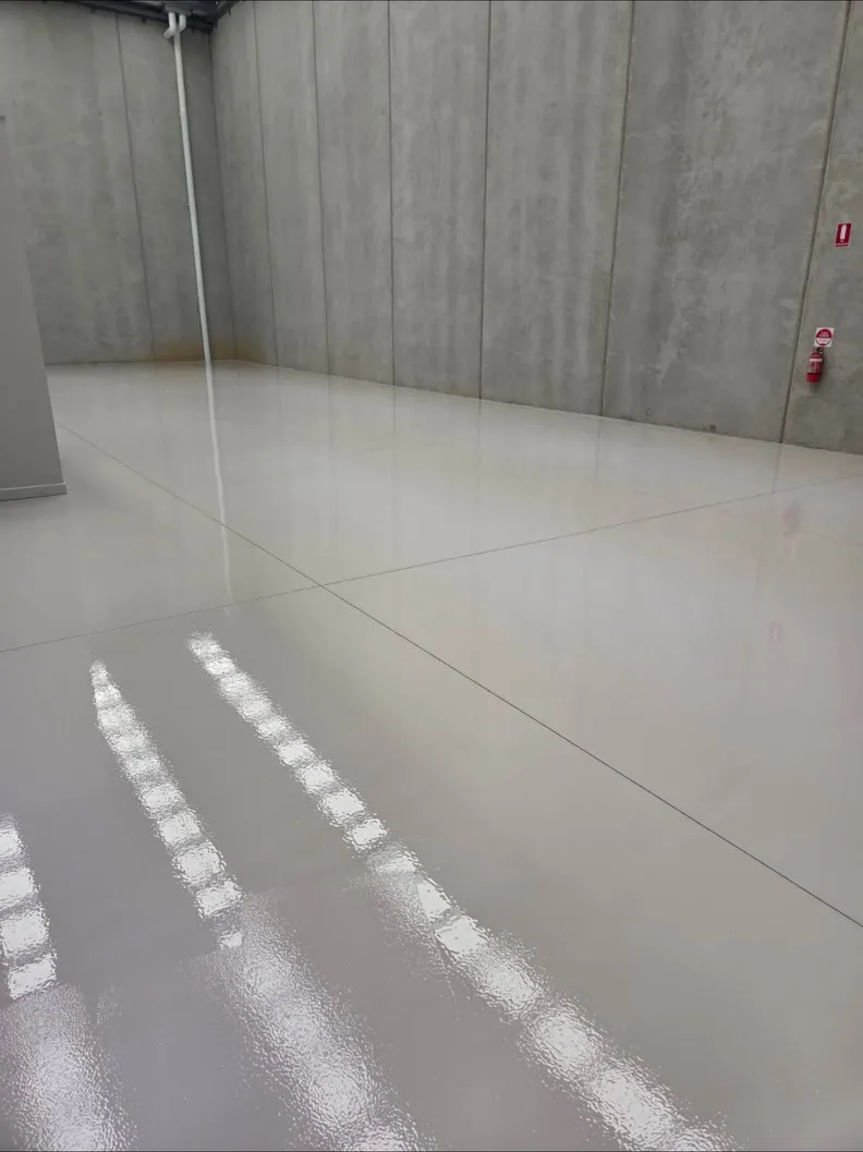 High-gloss sealed warehouse floor reflecting the walls