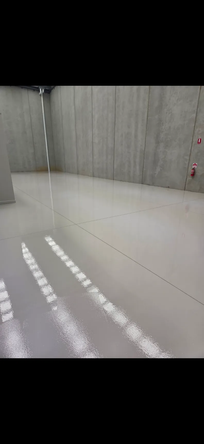 High-gloss warehouse floor reflecting overhead lights