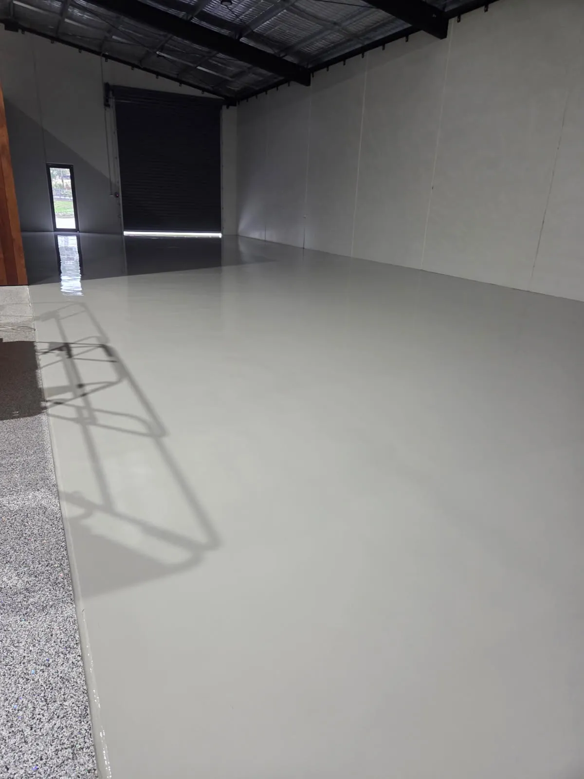 Light-grey epoxy floor with flake border in a workshop